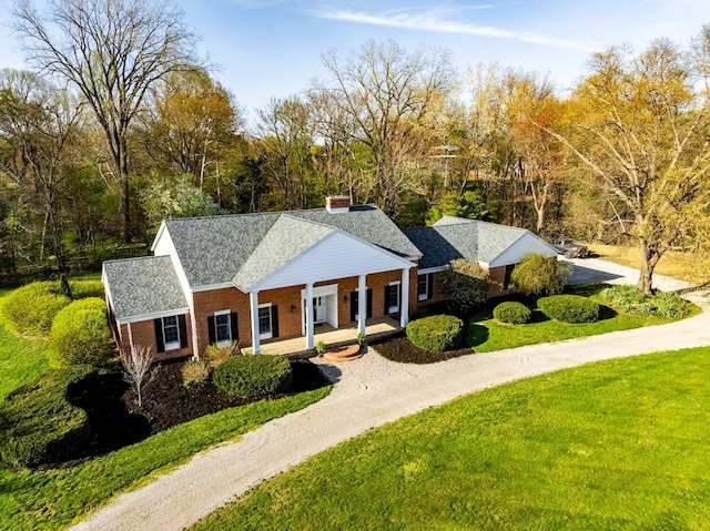 4107 State Route 113, Milan, OH 44846 - neoclassical home with a front yard, a chimney, covered porch, driveway, and brick siding