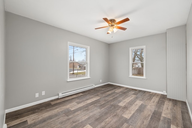 empty room with a baseboard heating unit, a healthy amount of sunlight, dark wood finished floors, and a ceiling fan