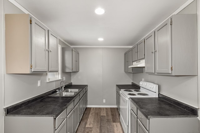 kitchen featuring white range with electric cooktop, dark countertops, gray cabinets, a sink, and under cabinet range hood