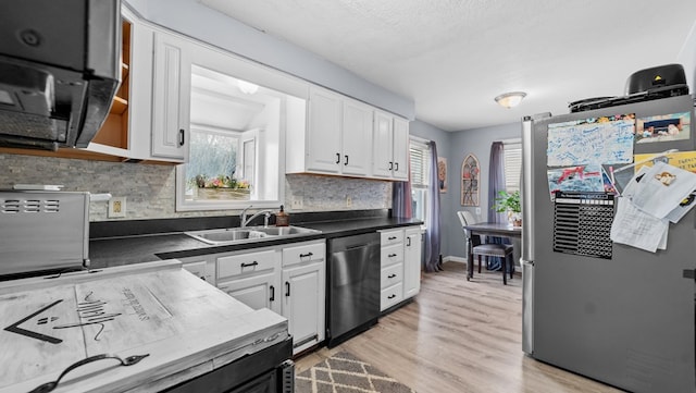 kitchen featuring appliances with stainless steel finishes, white cabinets, and sink