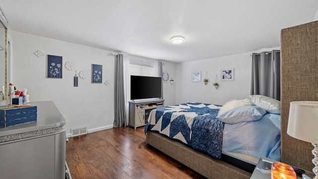 bedroom with dark hardwood / wood-style floors