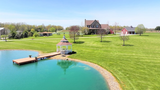 view of community featuring a yard, a water view, a gazebo, and a floating dock