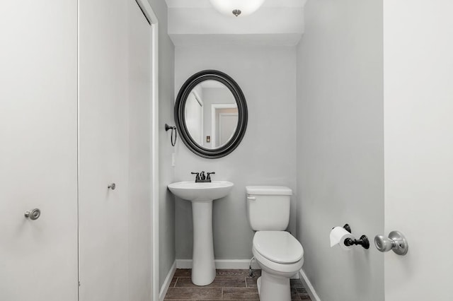 828 Longmeadow Ln, Findlay, OH 45840 - half bathroom with toilet, baseboards, wood finished floors, and a sink