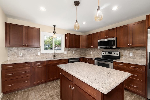 828 Longmeadow Ln, Findlay, OH 45840 - kitchen featuring appliances with stainless steel finishes, a sink, decorative light fixtures, tasteful backsplash, and a center island