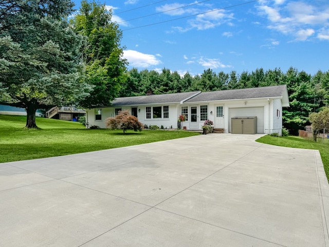 ranch-style home featuring an attached garage, driveway, and a front yard