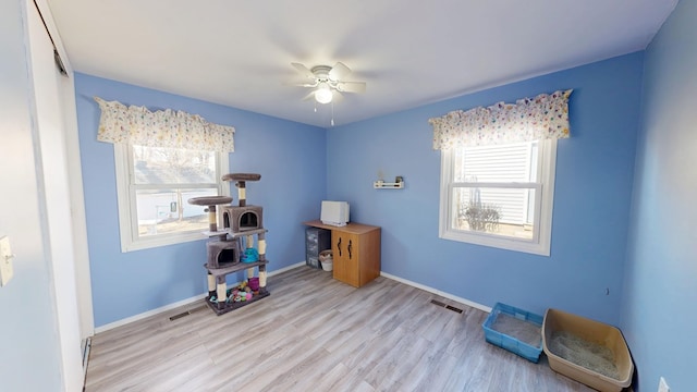 misc room with visible vents, baseboards, wood finished floors, and a ceiling fan