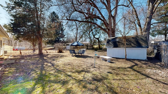 view of yard featuring a storage shed, an outdoor structure, and fence