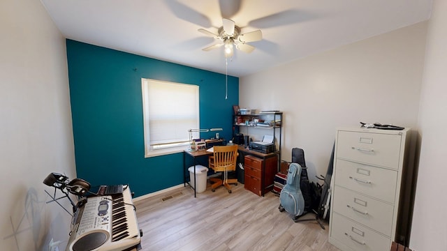 office with light wood-type flooring, visible vents, baseboards, and ceiling fan