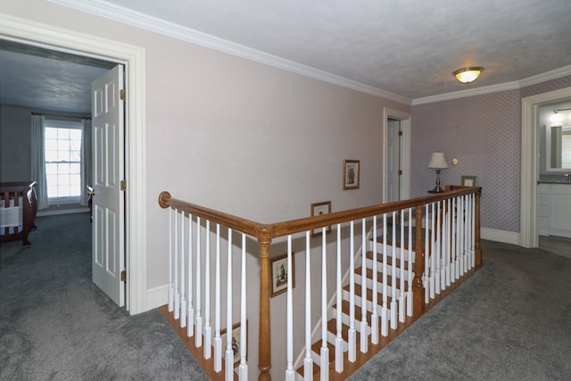 hallway with baseboards, ornamental molding, an upstairs landing, and carpet floors