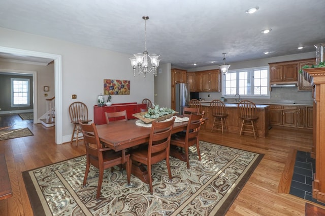dining space featuring a chandelier, light wood-type flooring, recessed lighting, and a wealth of natural light