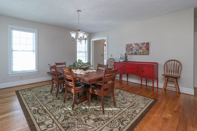 dining room with baseboards, wood finished floors, and a chandelier