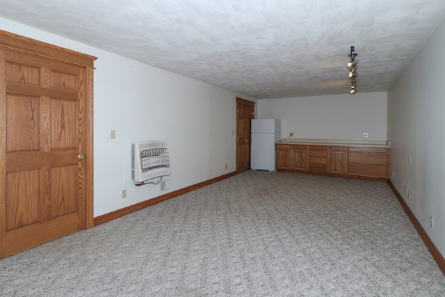 unfurnished room with light colored carpet, baseboards, and heating unit