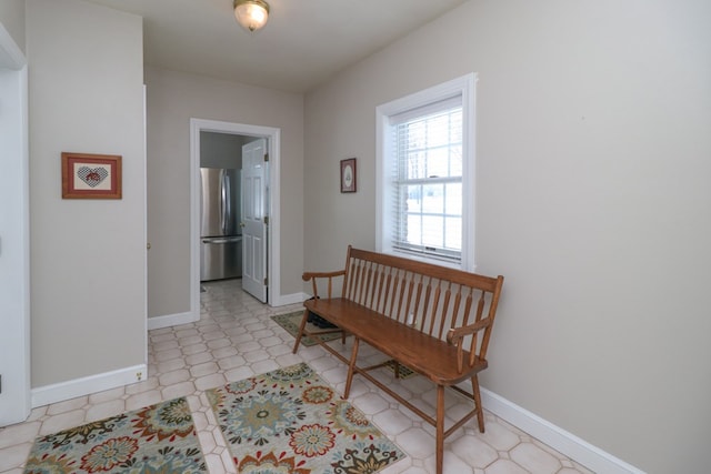hallway featuring baseboards and light floors