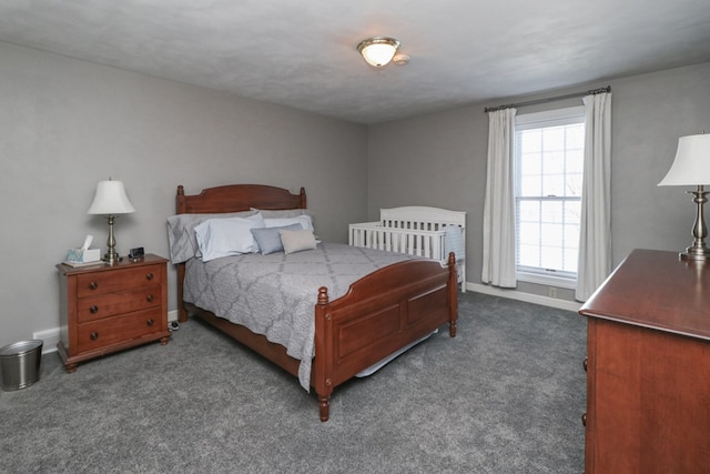 bedroom featuring dark colored carpet and baseboards
