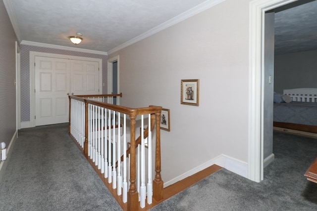 hall featuring baseboards, carpet, an upstairs landing, and crown molding