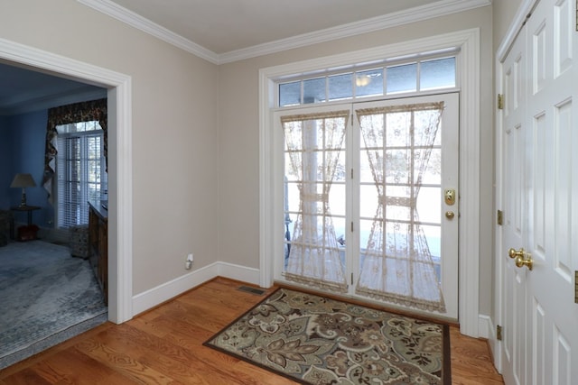 doorway featuring crown molding, visible vents, baseboards, and light wood-type flooring
