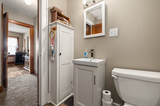 half bathroom featuring vanity and toilet