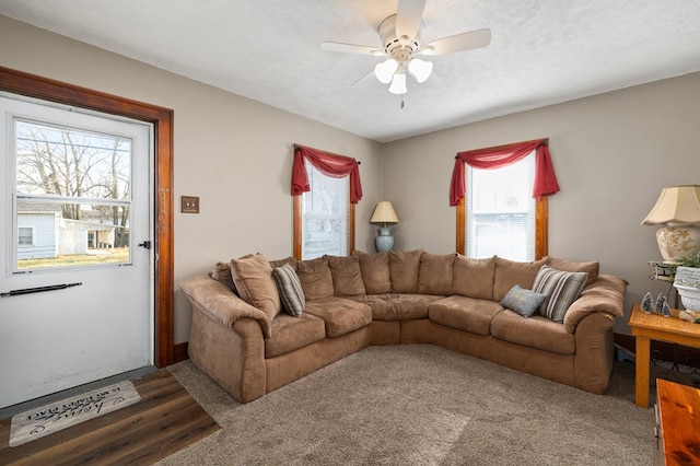 living area featuring a ceiling fan, a healthy amount of sunlight, and a textured ceiling