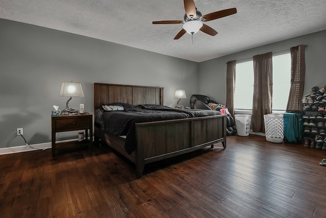 bedroom with ceiling fan, dark wood-type flooring, and a textured ceiling