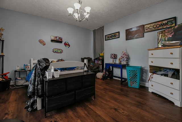 bedroom featuring dark hardwood / wood-style flooring, a textured ceiling, and a notable chandelier