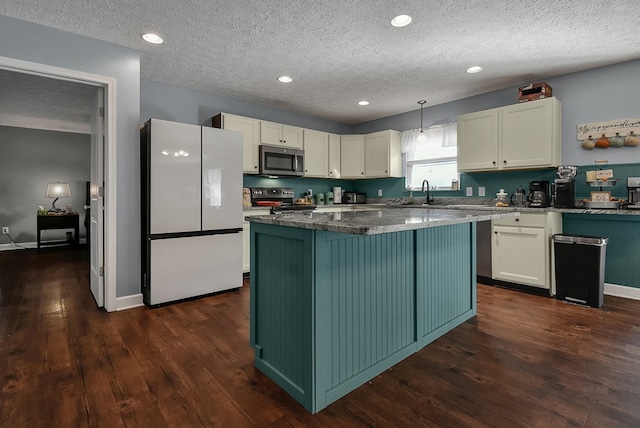 kitchen featuring a center island, stainless steel appliances, light stone counters, pendant lighting, and a textured ceiling