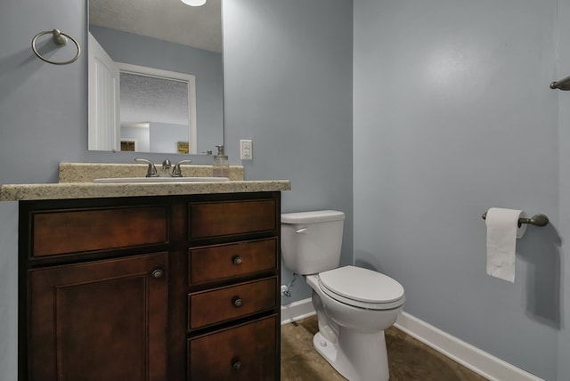 bathroom with a textured ceiling, vanity, and toilet