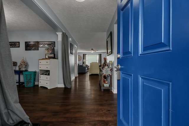 foyer entrance featuring ceiling fan, dark hardwood / wood-style flooring, and a textured ceiling