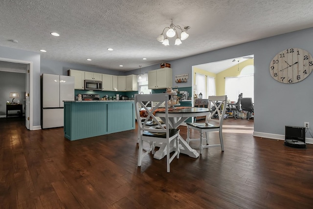 dining room featuring dark wood-type flooring, a textured ceiling, and a notable chandelier