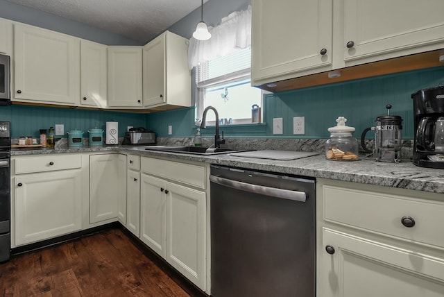 kitchen featuring pendant lighting, dark wood-type flooring, sink, a textured ceiling, and appliances with stainless steel finishes