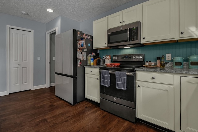 kitchen with dark hardwood / wood-style floors, a textured ceiling, and appliances with stainless steel finishes