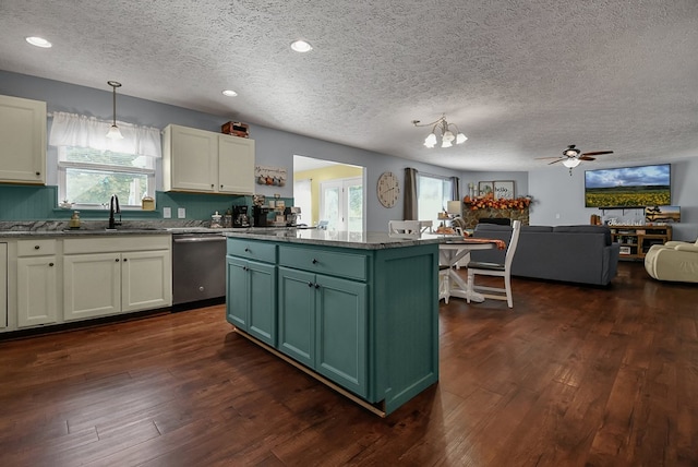 kitchen with a center island, sink, hanging light fixtures, stainless steel dishwasher, and a textured ceiling