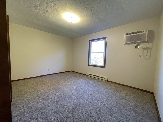 71 Taft St, Shelby, OH 44875 - carpeted spare room featuring a baseboard radiator, a textured ceiling, baseboards, and a wall mounted air conditioner