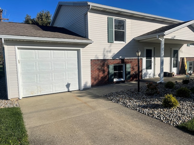71 Taft St, Shelby, OH 44875 - view of front of home with driveway, an attached garage, and brick siding
