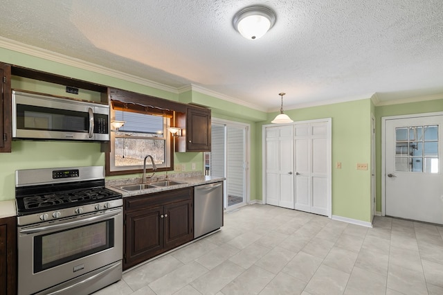 kitchen with pendant lighting, a sink, stainless steel appliances, dark brown cabinetry, and baseboards