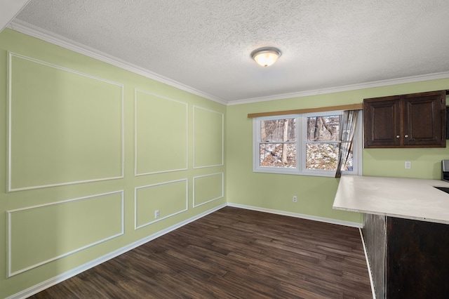 unfurnished dining area featuring crown molding, a decorative wall, dark wood-style floors, and a textured ceiling