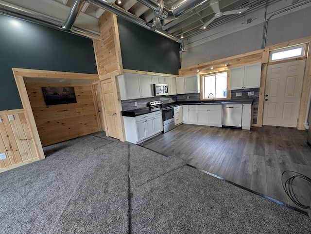 115 N Main St, Mount Gilead, OH 43338 - kitchen with dark countertops, a high ceiling, wooden walls, and stainless steel appliances