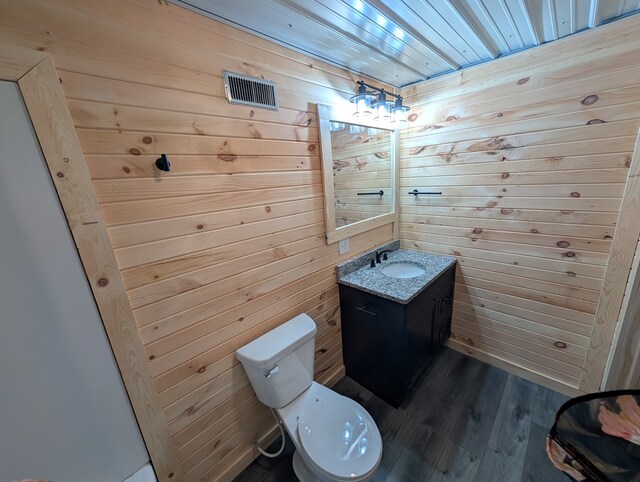115 N Main St, Mount Gilead, OH 43338 - bathroom featuring wood finished floors, toilet, vanity, and wood walls