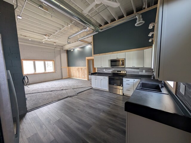115 N Main St, Mount Gilead, OH 43338 - kitchen featuring open floor plan, stainless steel appliances, dark wood finished floors, dark countertops, and white cabinets