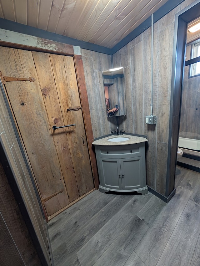 115 N Main St, Mount Gilead, OH 43338 - full bath with wooden walls, wood finished floors, toilet, vanity, and wooden ceiling