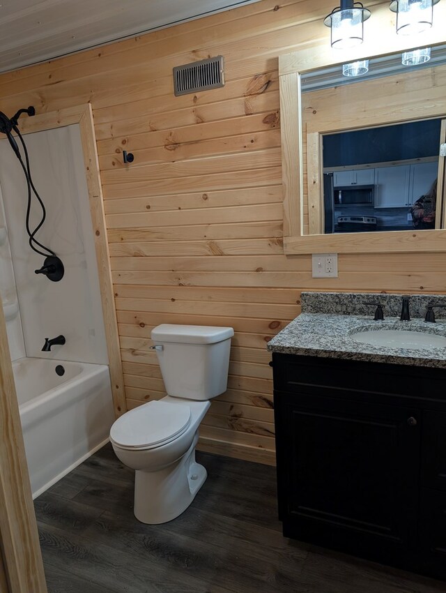 115 N Main St, Mount Gilead, OH 43338 - full bath featuring toilet, vanity, shower / tub combination, wooden walls, and wood finished floors