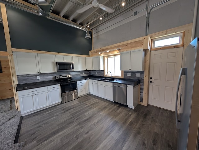 115 N Main St, Mount Gilead, OH 43338 - kitchen featuring a sink, a high ceiling, tasteful backsplash, appliances with stainless steel finishes, and dark countertops