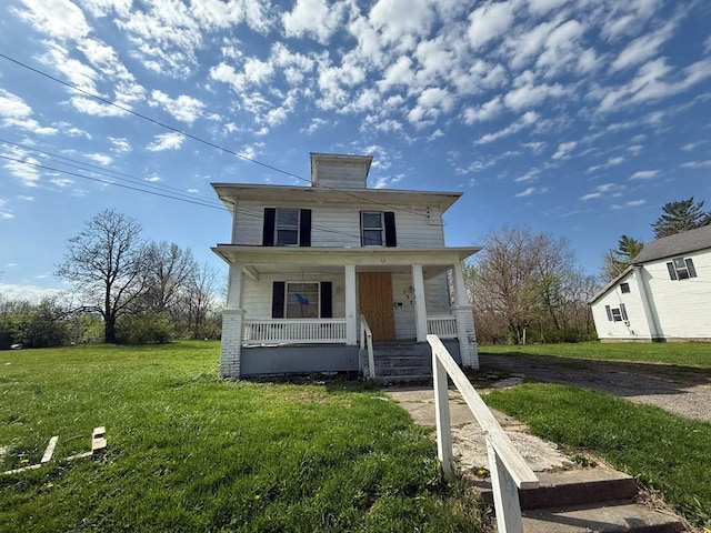 american foursquare style home featuring a porch and a front lawn