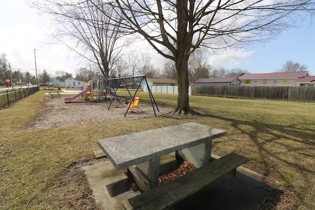 community play area featuring fence and a yard