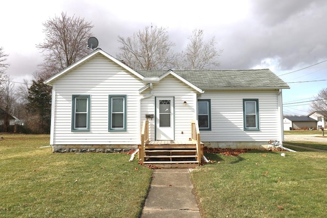 view of front of house with a shingled roof and a front yard