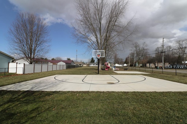 view of basketball court featuring community basketball court, a lawn, and fence