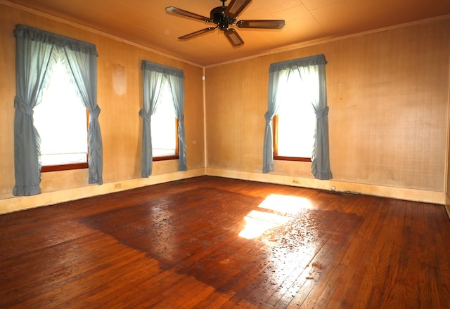 empty room featuring ornamental molding, a ceiling fan, and hardwood / wood-style flooring