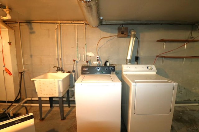 laundry room with laundry area, independent washer and dryer, and a sink