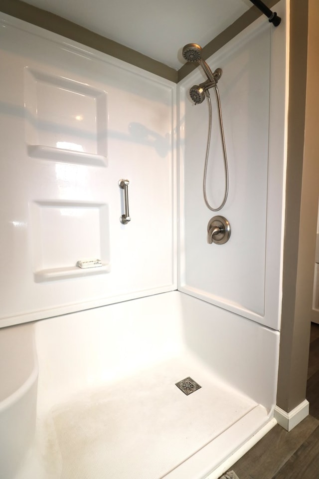 bathroom featuring wood finished floors and walk in shower