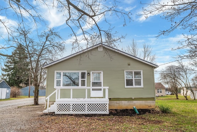 rear view of property featuring a lawn