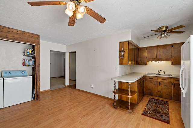 kitchen featuring light hardwood / wood-style floors, sink, white fridge, and a textured ceiling